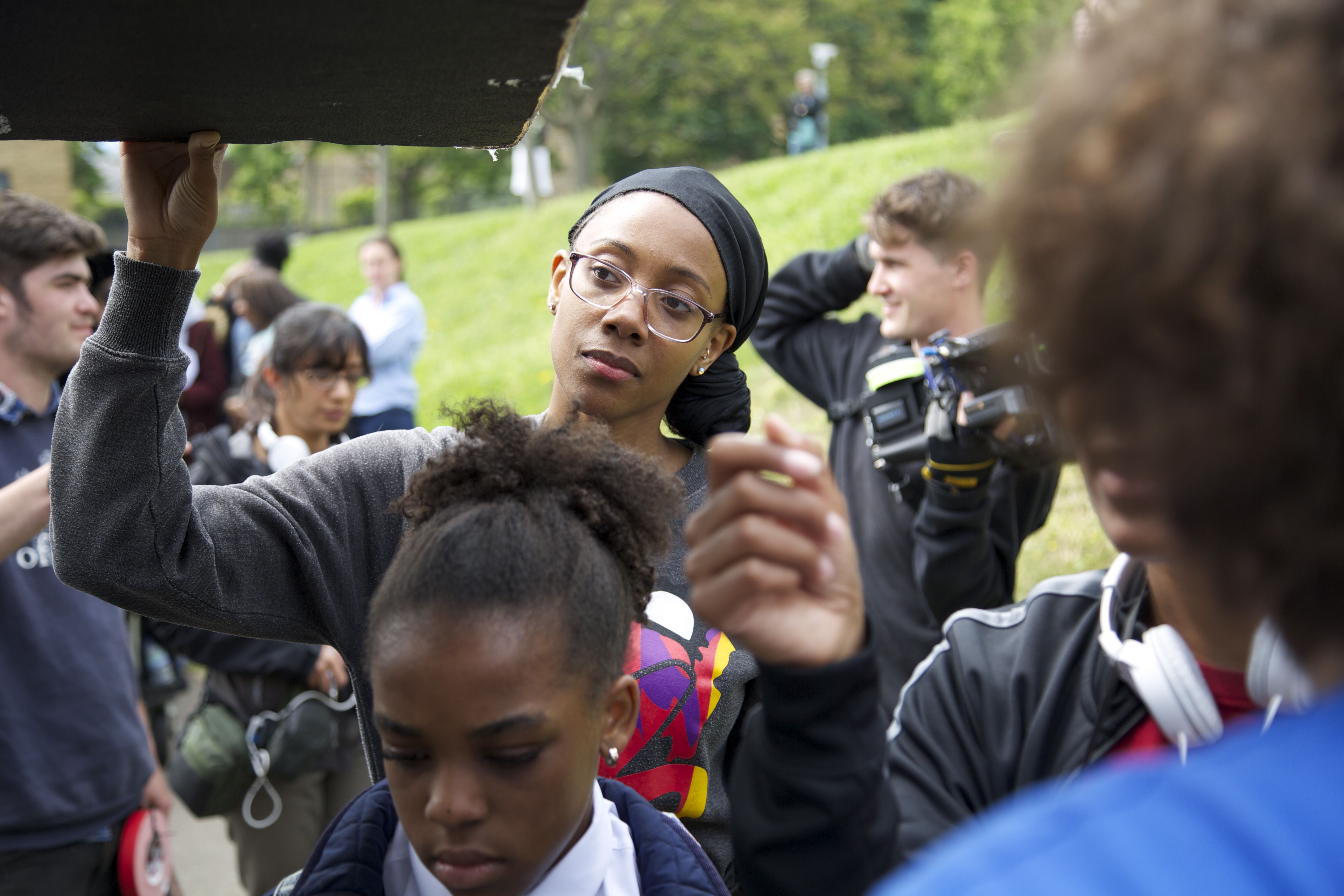 Behind the scenes on We Love Moses, the crew shooting on a grass bank with young cast