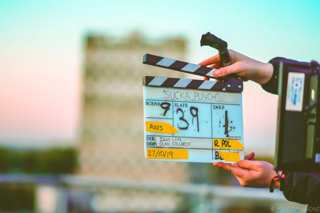 Behind the scenes on Sucka Punch, the clapperboard held up on a rooftop at dusk