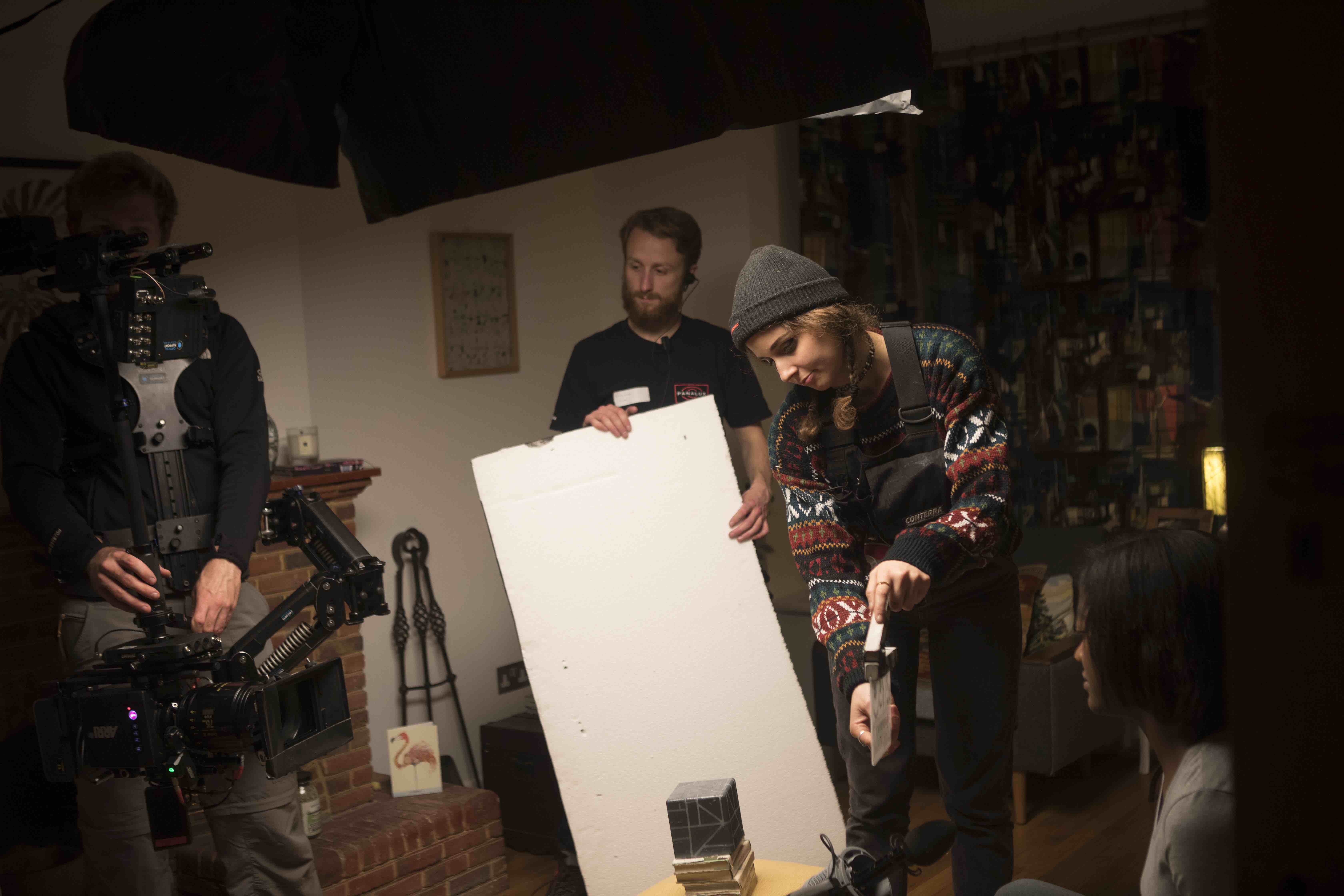 Behind the scenes on Transference, the crew setting a bounce board in a living room