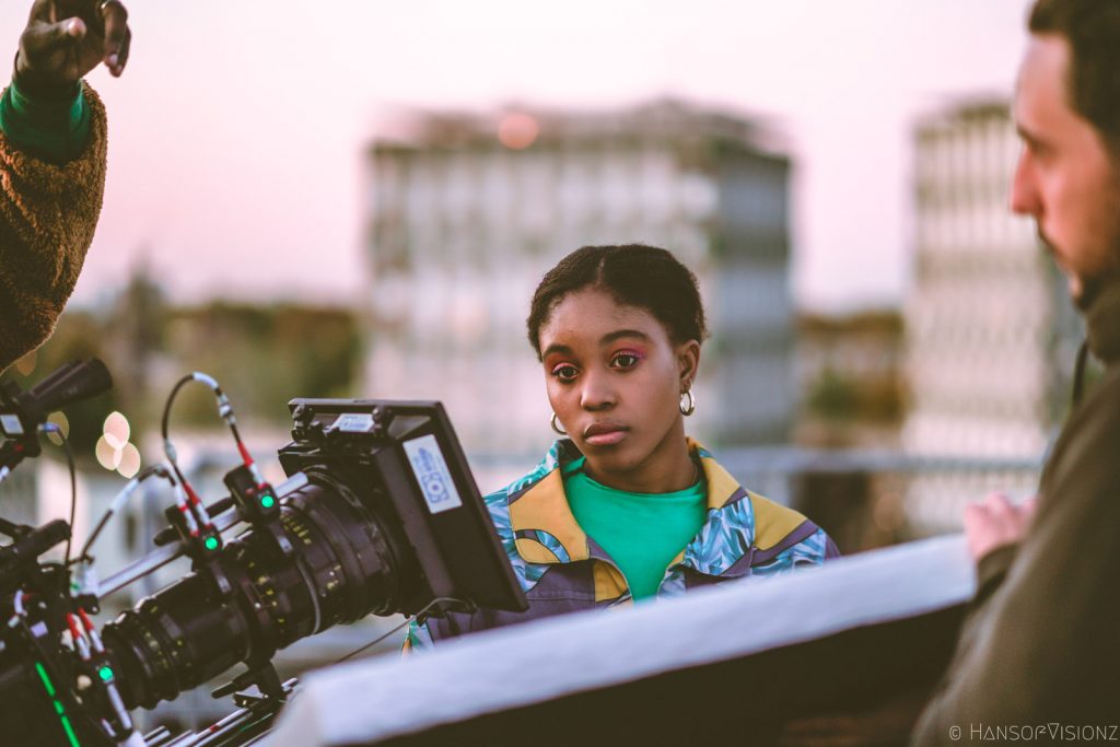 Behind the scenes on Sucka Punch, the lead framed beside the camera on a rooftop
